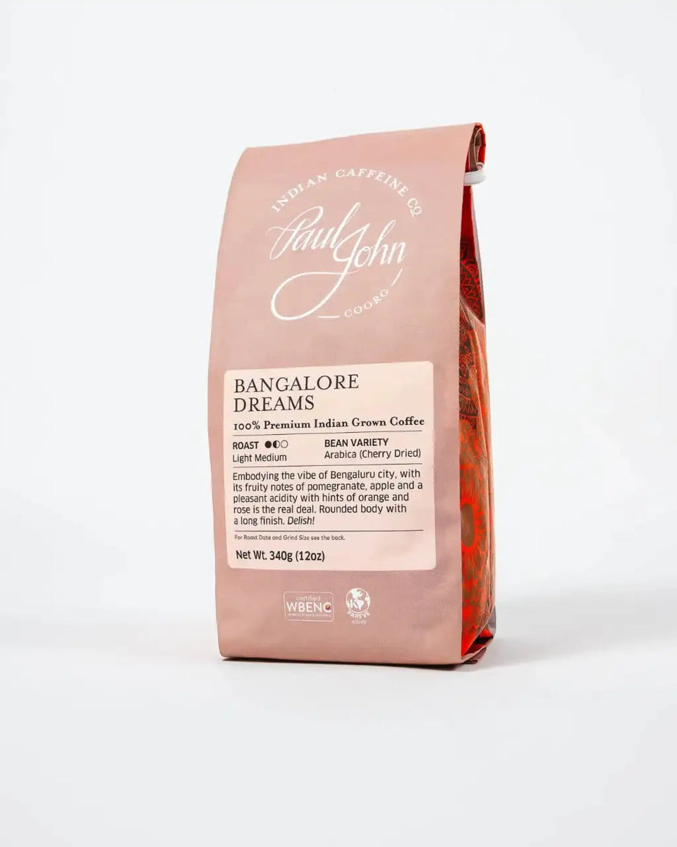 A bag of Paul John Coffee's Bangalore Dreams whole bean coffee, presented in a dusty rose pink bag with a white label, set against a clean white background.