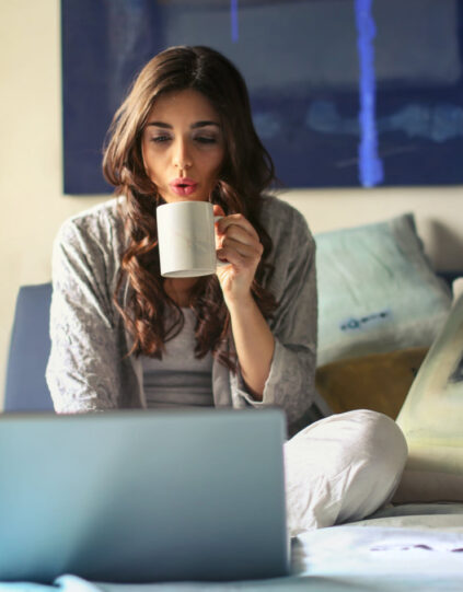 woman sipping coffee while working