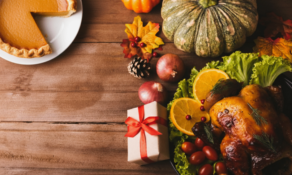 A dark, rustic wooden table with an autumn border of fall leaves, pears, and orange berries. The gifts wrapped in brown paper and scattered coffee beans make this the perfect inspiration for Thanksgiving gift ideas and Thanksgiving coffee gifts.
